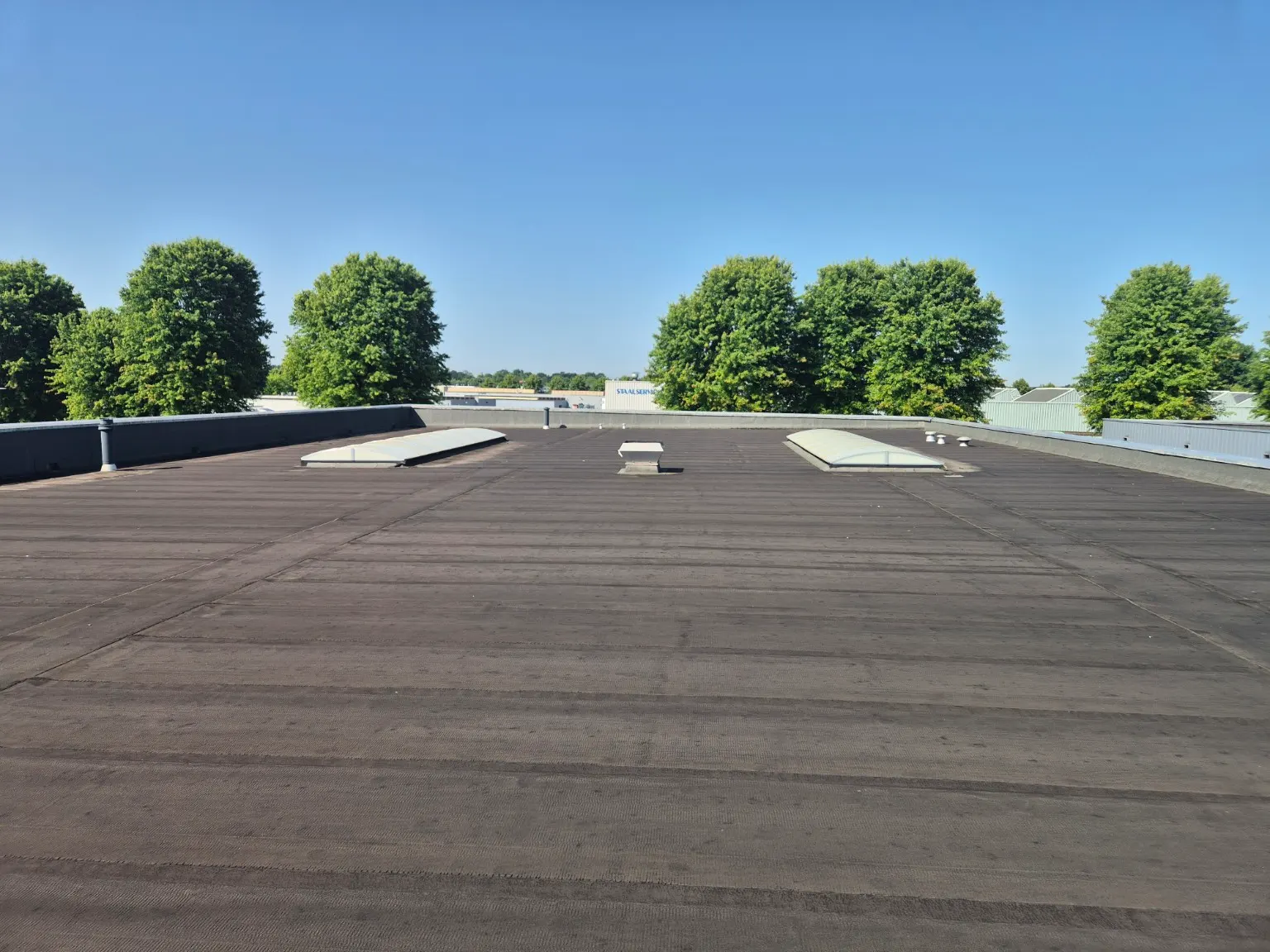 Verouderd bitumen bedrijfsdak in Weert voor de renovatie